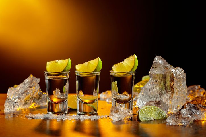 The tequila is poured from the bottle into shot glasses.