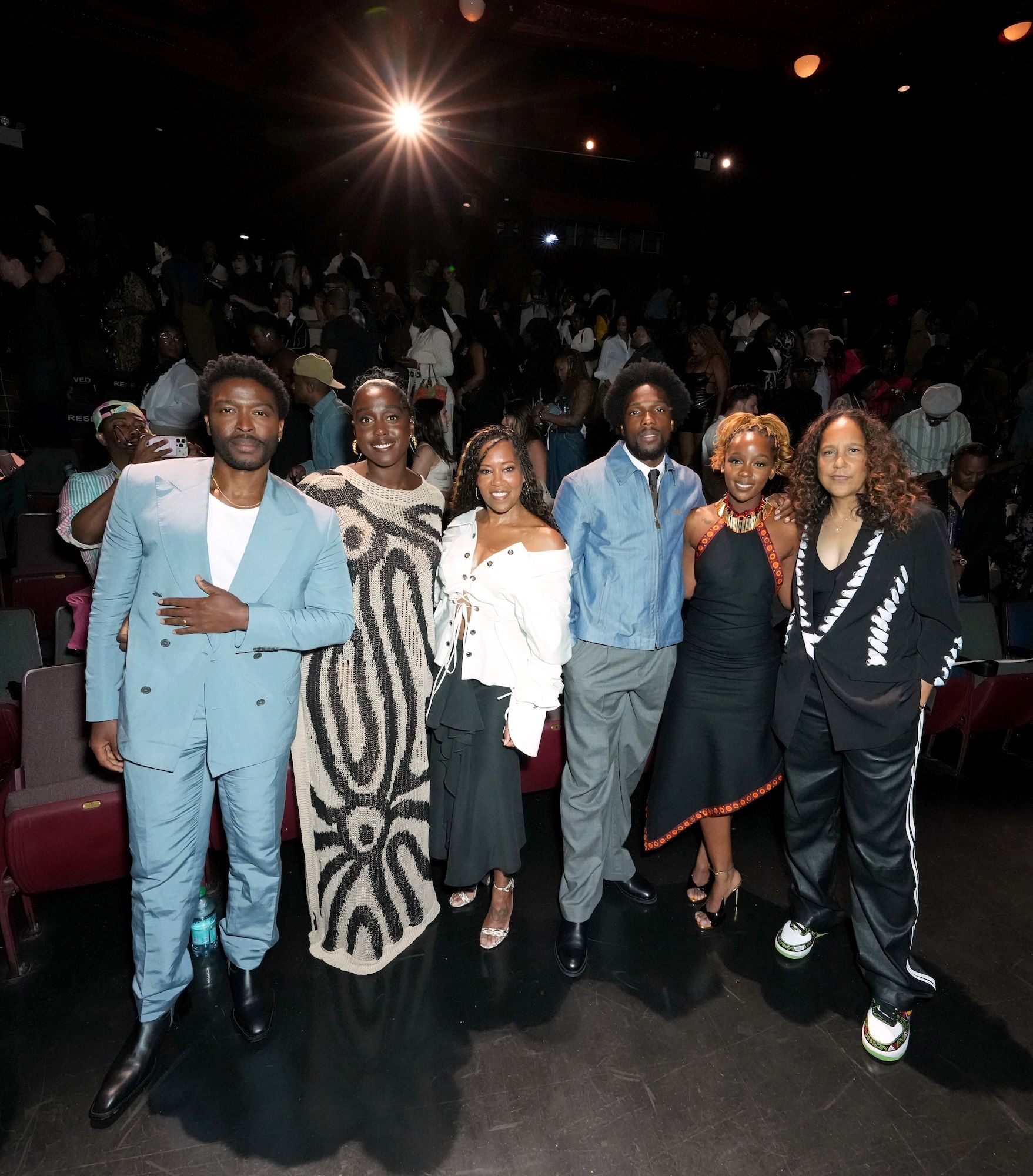 A group of six people, including actors Zackary Momoh, Lashana Lynch, Regina King, Tosin Cole, Thuso Mbedu, and director Gina Prince-Bythewood, posing together at an event.